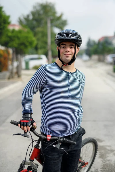 Retrato del síndrome de Down hombre adulto con bicicleta de pie al aire libre en la calle. — Foto de Stock
