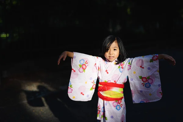 Retrato de menina japonesa pequena vestindo quimono ao ar livre na cidade. — Fotografia de Stock