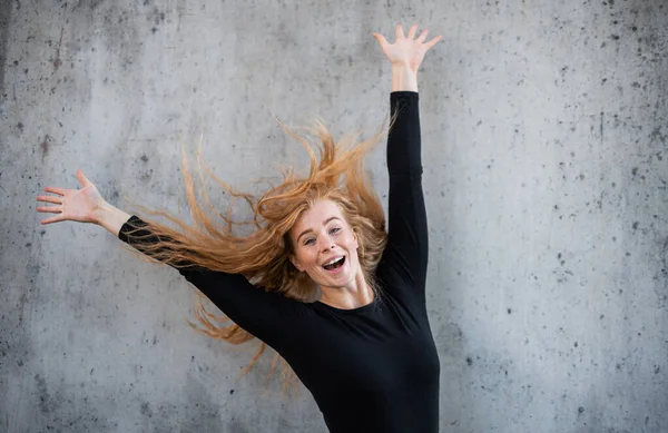 Retrato de una joven alegre con el pelo rojo de pie sobre fondo gris. — Foto de Stock