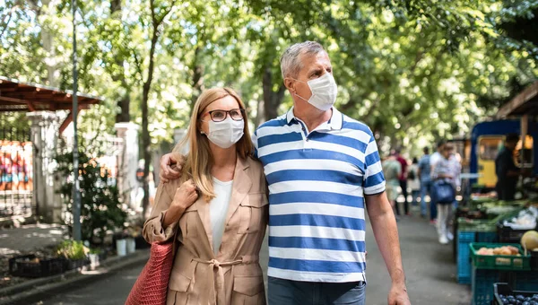 Retrato de casal sênior feliz andando ao ar livre na cidade ou cidade, conceito de coronavírus. — Fotografia de Stock