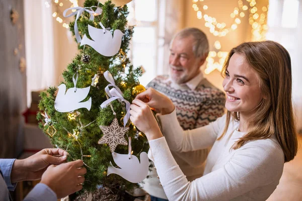 Homens e mulheres parentes da família dentro de casa no Natal, árvore de decoração. — Fotografia de Stock