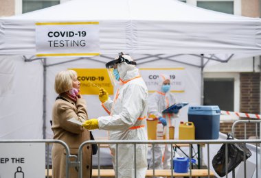 Caddedeki covid-19 test merkezinde kıdemli bir kadın. Coronavirus ve pamuklu çubuk konsept alıyor..