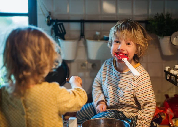 Niño y niña en el interior de la cocina en casa, ayudando con la cocina. —  Fotos de Stock