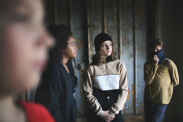 Grupp tonåringar gäng står inomhus i övergiven byggnad, mobbning koncept. — Stockfoto