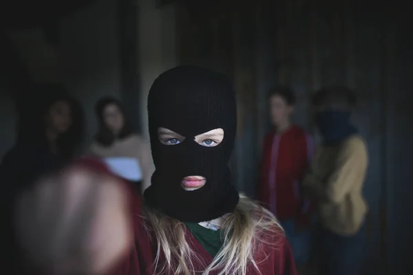 Chica con máscara de adolescentes pandilla de pie en el interior de un edificio abandonado, atacando con el puño. — Foto de Stock