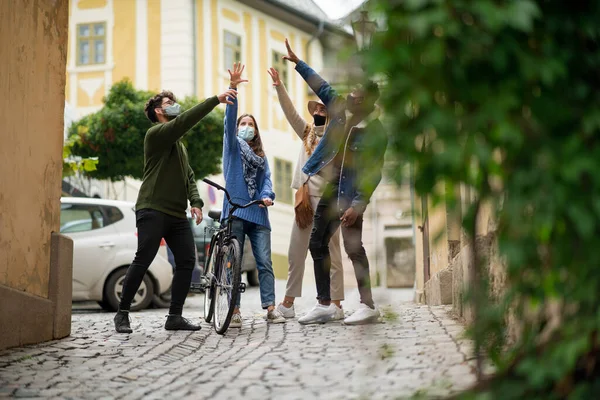 Gruppe junger Leute mit Fahrrad im Freien in der Stadt, zu Fuß. Coronavirus-Konzept. — Stockfoto