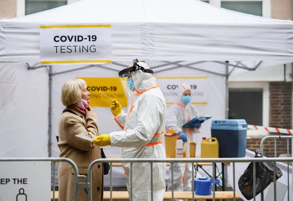 Старшая женщина в ковид-19 центр тестирования на открытом воздухе на улице, коронавирус и мазок принимая концепцию. — стоковое фото