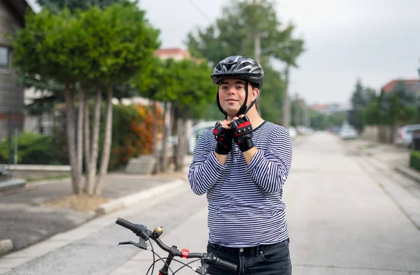 Портрет синдрома Дауна взрослый мужчина с велосипедом стоит на улице. — стоковое фото