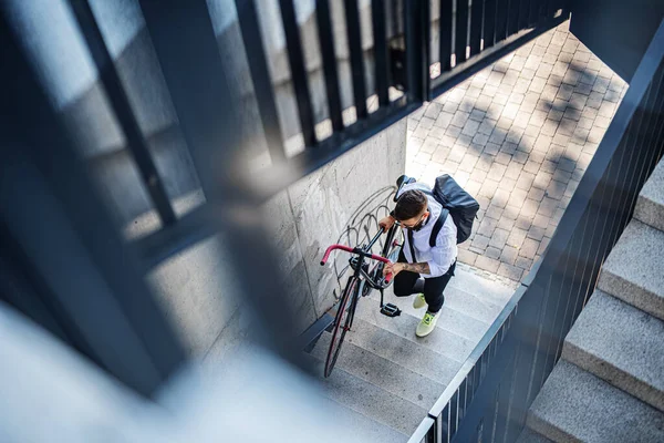 Joven viajero con bicicleta subiendo las escaleras al aire libre en la ciudad. — Foto de Stock