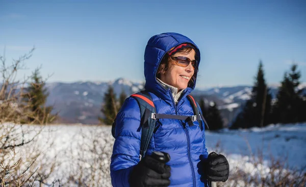 Retrato de una mujer mayor de pie en la naturaleza invernal cubierta de nieve. — Foto de Stock