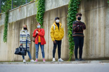 Kasabanın dışında duran genç insanlar. Coronavirus ve güvenli mesafe konsepti.