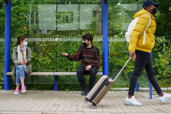 Les jeunes qui parlent en bus s'arrêtent à l'extérieur en ville. Concept de coronavirus. — Photo