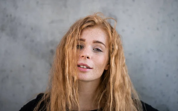 Retrato de jovem alegre com cabelo vermelho em pé contra fundo cinza. — Fotografia de Stock