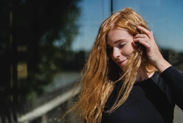 Retrato de uma jovem com cabelo ruivo ao ar livre na cidade. Espaço de cópia. — Fotografia de Stock