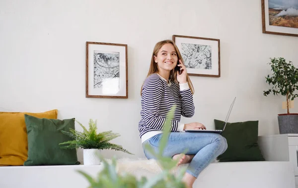 Jeune étudiant avec ordinateur portable et smartphone travaillant à la maison, concept coronavirus. — Photo