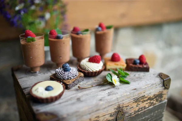 Výběr barevných a lahodných dortových dezertů na rezavé dřevěné krabici. — Stock fotografie