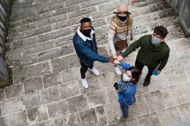 Şehrin dışında selamlaşan bir grup gencin en iyi görüntüsü. Coronavirus konsepti.