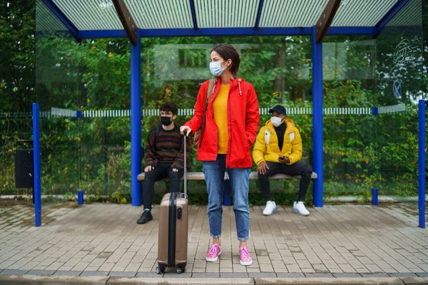 Молодые люди на автобусной остановке в городе. Коронавирусная концепция. — стоковое фото