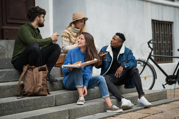 Grupo de jovens ao ar livre na cidade, comendo pizza. Conceito de coronavírus. — Fotografia de Stock