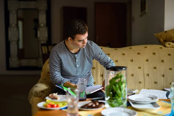 Down syndrome adult man sitting indoors at home, resting on sofa. — Stock Photo, Image