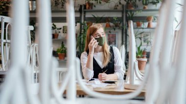 Hüsrana uğramış sahibi kapalı kafede masada oturuyor, Coronavirus yüzünden küçük işletme kilitlenmesi..