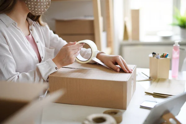 Mujer irreconocible dropshipper que trabaja en casa, paquetes de embalaje. Concepto de Coronavirus. — Foto de Stock