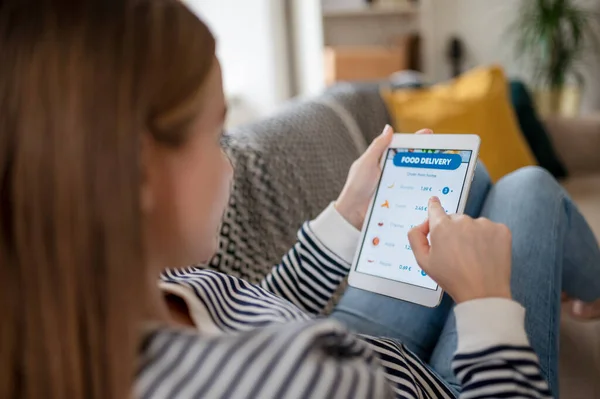 Jeune femme avec tablette commander de la nourriture à la maison, coronavirus et concept de livraison de nourriture. — Photo