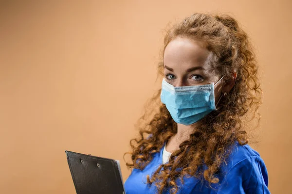 Tânără femeie doctor într-un studio care deține clipboard, conceptul de coronavirus . — Fotografie, imagine de stoc