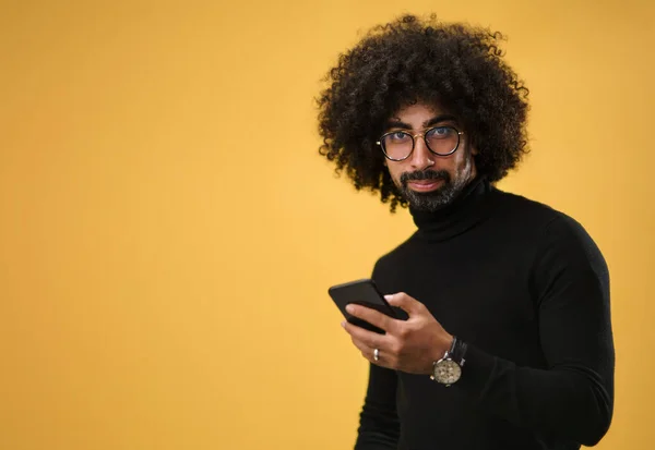 Ritratto di uomo maturo con smartphone in uno studio su sfondo giallo. — Foto Stock