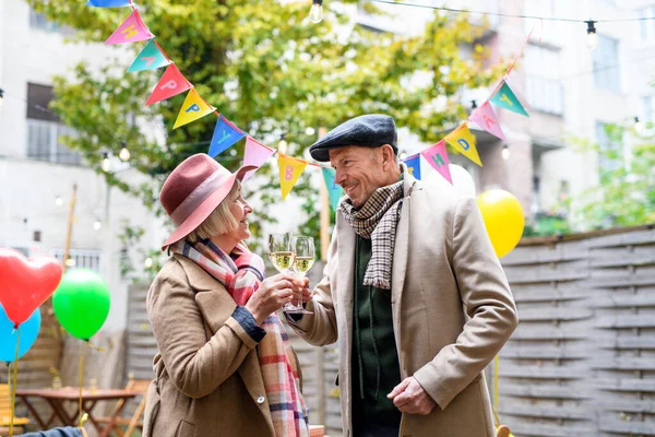 Felice coppia anziana con vino in caffè all'aperto in città, festeggiando il compleanno. — Foto Stock