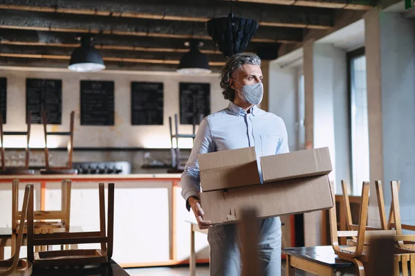 Frustrated owner carrying boxes in closed cafe, small business lockdown due to coronavirus. — Stock Photo, Image