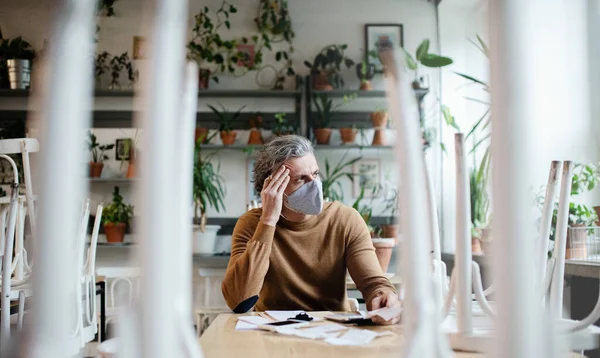 Propriétaire frustré assis à table dans un café fermé, verrouillage de la petite entreprise en raison du coronavirus. — Photo