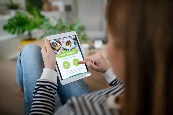 Mujer joven con tableta pidiendo comida en casa, coronavirus y el concepto de entrega de alimentos. —  Fotos de Stock