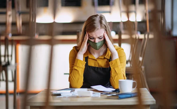 Propriétaire frustré assis à table dans un café fermé, verrouillage de la petite entreprise en raison du coronavirus. — Photo