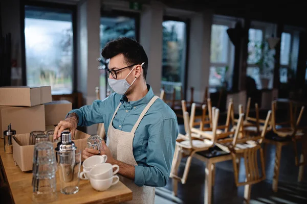 Cameriere frustrato imballaggio bicchieri in caffè chiuso, chiusura di piccole imprese a causa di coronavirus. — Foto Stock