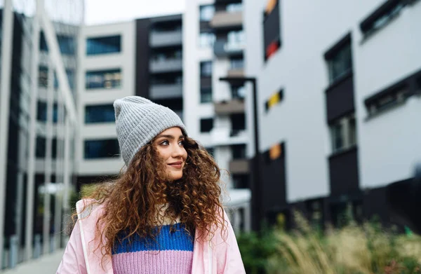 Young woman with hat standing outdoors on street. — Stock Photo, Image