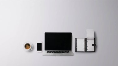 Üst kattaki ofis masası gri arka planda dizüstü bilgisayarla çalışıyordu. Boşluğu kopyala.