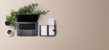 Üst kattaki ofis masası gri arka planda dizüstü bilgisayarla çalışıyordu. Boşluğu kopyala.