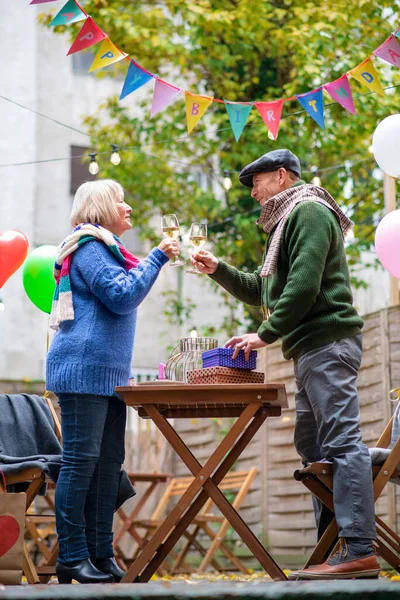 Felice coppia anziana con vino in caffè all'aperto in città, festeggiando il compleanno. — Foto Stock