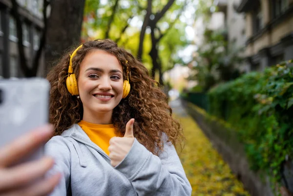 Giovane donna con smartphone all'aperto per strada, video per il concetto di social media. — Foto Stock