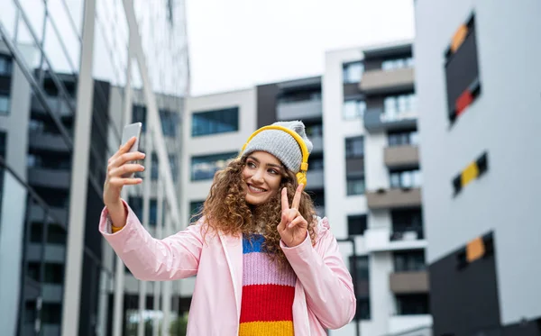 Young woman with smartphone making video for social media outdoors on street. — Stock Photo, Image