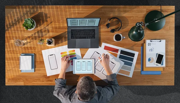 Top view of creative businessman working on computer at desk in home office.