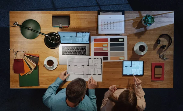 Vista superior de los arquitectos que trabajan en la computadora en el escritorio con papeleo en la oficina. —  Fotos de Stock