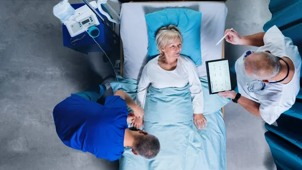 Bovenaanzicht van artsen met stethoscoop die patiënten onderzoeken in bed in het ziekenhuis. Kopieerruimte. — Stockfoto
