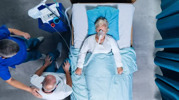 Draufsicht auf Ärzte und Covid-19-Patient mit Sauerstoffmaske im Krankenhausbett, Coronavirus-Konzept. — Stockfoto
