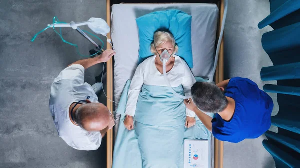 Ovanifrån av läkare och covid-19 patient med syrgasmask i sängen på sjukhus, coronavirus koncept. — Stockfoto