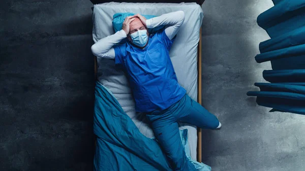 Vedere de top a medicului frustrat întins pe pat în spital, conceptul de coronavirus . — Fotografie, imagine de stoc