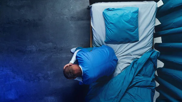 Visão superior do médico frustrado sentado na cama no hospital, conceito de coronavírus. — Fotografia de Stock