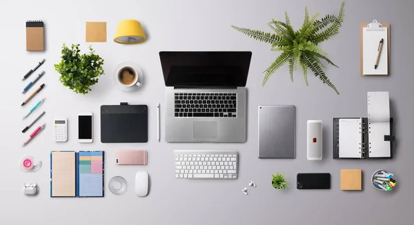 Flat lay vista superior escritório mesa de trabalho espaço com laptop e suprimentos em fundo cinza. — Fotografia de Stock