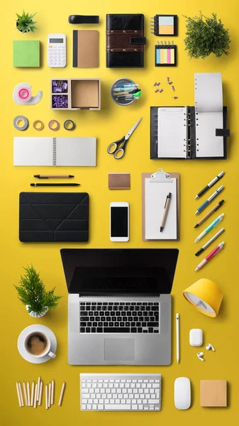 Рабочее место с ноутбуком и принадлежностями на желтом фоне. — стоковое фото
